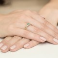 Złoty pierścionek ozdobiony diamentami i szmaragdem 0,50 ct